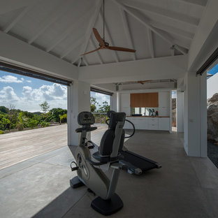 Foto di una palestra multiuso tropicale con pareti bianche e pavimento in cemento