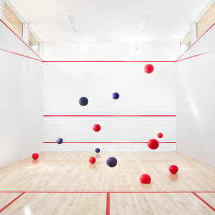 Esempio di un ampio campo sportivo coperto contemporaneo con pareti bianche, pavimento in laminato e pavimento marrone