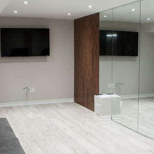 Foto di una grande sala pesi moderna con pareti grigie, pavimento in laminato e pavimento bianco
