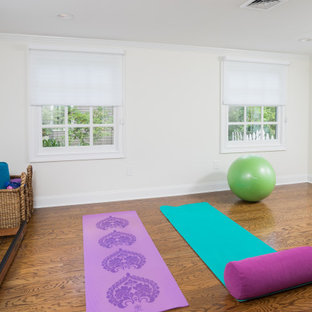 Ispirazione per un piccolo studio yoga classico con pareti bianche, pavimento in legno massello medio e pavimento marrone