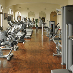 Esempio di una grande palestra multiuso mediterranea con pavimento in legno massello medio