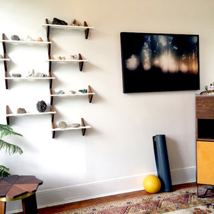 Foto di una piccola palestra in casa minimal con pareti bianche, pavimento in legno massello medio e pavimento marrone