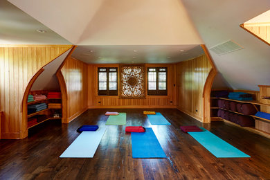 Mittelgroßer Asiatischer Yogaraum mit dunklem Holzboden, braunem Boden und brauner Wandfarbe in Chicago