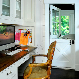 Landhaus Arbeitszimmer mit weißer Wandfarbe, dunklem Holzboden und Einbau-Schreibtisch in New York