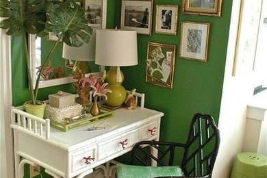 Imagen de despacho exótico pequeño con paredes verdes, suelo de madera clara y escritorio independiente