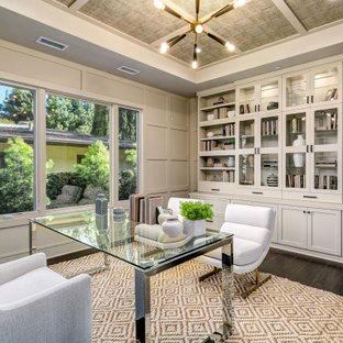 Klassisches Arbeitszimmer mit grauer Wandfarbe, dunklem Holzboden, freistehendem Schreibtisch, braunem Boden, eingelassener Decke, Tapetendecke und Wandpaneelen in Los Angeles