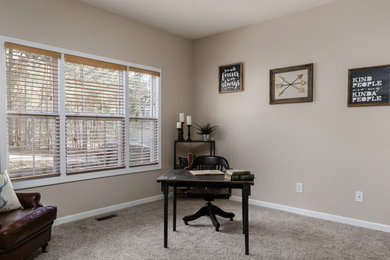 Diseño de despacho de estilo americano de tamaño medio con paredes beige, moqueta, escritorio independiente y suelo beige