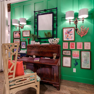 Cette image montre un bureau ethnique de type studio avec un mur vert, un sol en bois clair et un bureau indépendant.