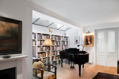 Photo of a medium sized contemporary home office in London with white walls, light hardwood flooring and beige floors.