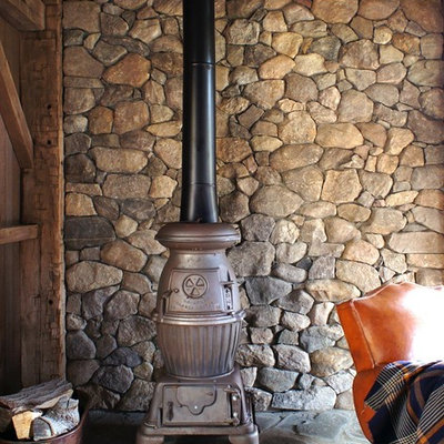 Example of a mid-sized farmhouse freestanding desk home office design in New York with a wood stove and brown walls