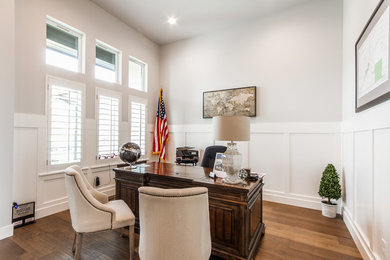 Imagen de despacho vintage de tamaño medio sin chimenea con paredes grises, suelo de madera en tonos medios, escritorio independiente y suelo marrón