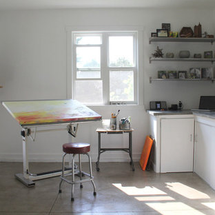 Exempel på ett litet industriellt hemmastudio, med vita väggar, ett fristående skrivbord och betonggolv
