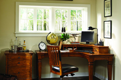 Home office - freestanding desk dark wood floor home office idea in Phoenix with yellow walls
