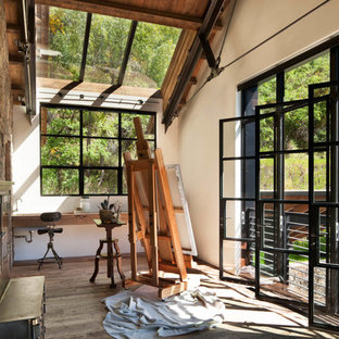 Foto di una stanza da lavoro rustica con pareti bianche, pavimento in legno massello medio, scrivania incassata e pavimento marrone