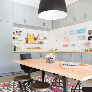 Industrial Nähzimmer mit weißer Wandfarbe, freistehendem Schreibtisch und grauem Boden in Seattle