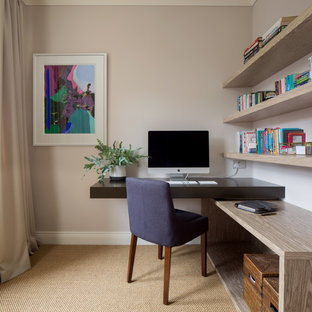 Inspiration för små klassiska hemmabibliotek, med beige väggar, ett inbyggt skrivbord, beiget golv och heltäckningsmatta