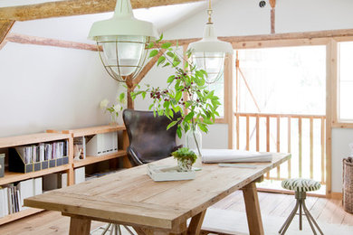 Ejemplo de despacho campestre con paredes blancas, escritorio independiente, suelo de madera clara y suelo beige