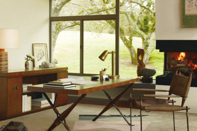 Ejemplo de despacho actual grande con paredes blancas, suelo de madera en tonos medios, todas las chimeneas y escritorio independiente