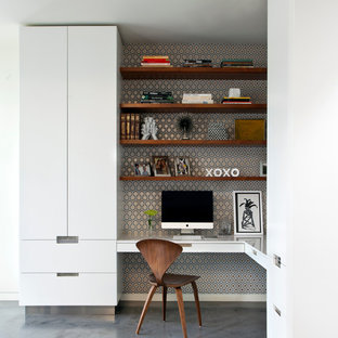 Réalisation d'un bureau design avec béton au sol, un bureau intégré et un mur multicolore.