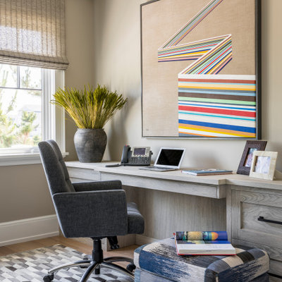 Study room - coastal built-in desk light wood floor study room idea in New York with beige walls