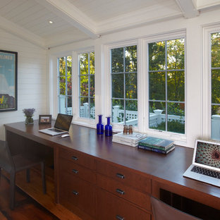 Example of a mid-sized transitional built-in desk medium tone wood floor home office design in New York with white walls and no fireplace