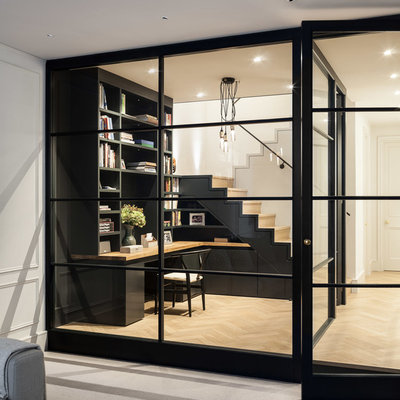Study room - small contemporary built-in desk light wood floor study room idea in London with black walls