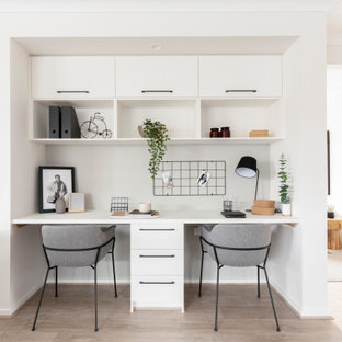 Aménagement d'un bureau industriel avec un mur blanc, sol en stratifié, un bureau intégré et un sol beige.