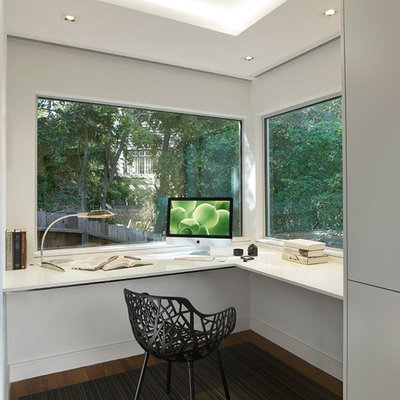 Example of a mid-sized minimalist built-in desk carpeted study room design in San Francisco with white walls