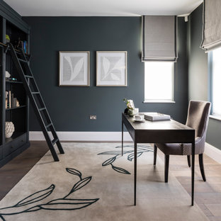 Inspiration for a large contemporary home office in London with grey walls, medium hardwood flooring, a freestanding desk and brown floors.