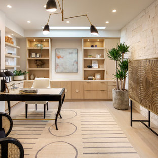 Modernes Arbeitszimmer mit beiger Wandfarbe, braunem Holzboden, freistehendem Schreibtisch und beigem Boden in Orange County