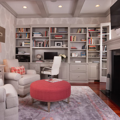 Home office library - mid-sized traditional built-in desk medium tone wood floor home office library idea in Atlanta with a two-sided fireplace and gray walls
