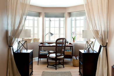 Foto de despacho clásico pequeño sin chimenea con paredes beige, suelo de madera clara, escritorio independiente y suelo beige