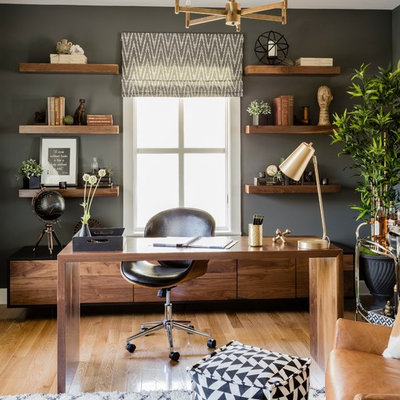 Example of a trendy freestanding desk medium tone wood floor and brown floor study room design in Boston with gray walls