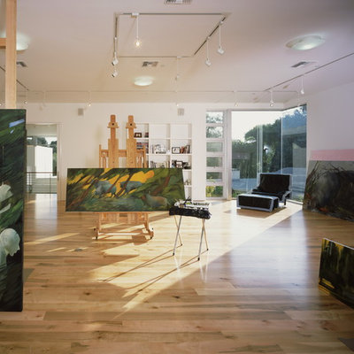 Example of a minimalist medium tone wood floor and beige floor home studio design in Los Angeles with white walls