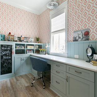 Inspiration för ett maritimt hemmabibliotek, med orange väggar, mellanmörkt trägolv, ett inbyggt skrivbord och brunt golv