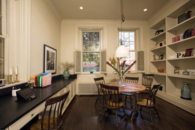 Example of a mid-sized classic freestanding desk dark wood floor craft room design in DC Metro with white walls