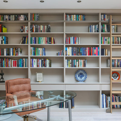 Home office library - large transitional freestanding desk light wood floor and gray floor home office library idea in Essex with beige walls