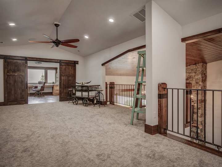 Mid-sized rustic built-in desk home studio idea with carpeting and white walls