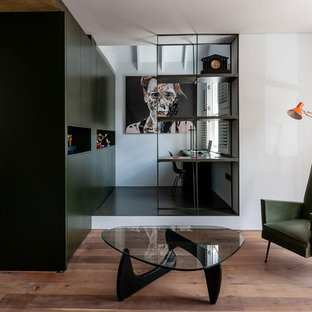 Design ideas for a small contemporary study in London with white walls, a built-in desk and black floors.