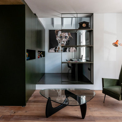 Inspiration for a small contemporary built-in desk black floor study room remodel in London with white walls