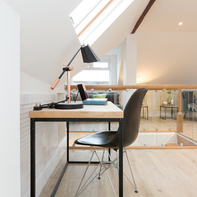 Example of a trendy freestanding desk light wood floor and beige floor home office design in London with white walls