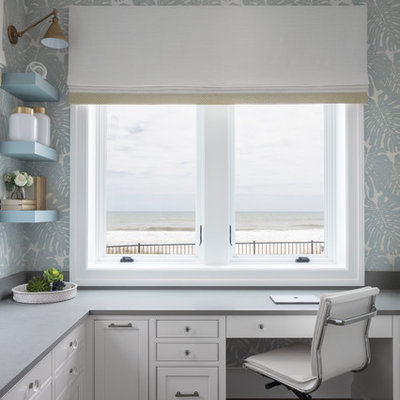 Beach style built-in desk dark wood floor study room photo in Jacksonville with blue walls