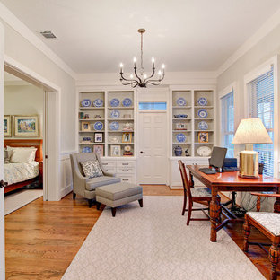 Study room - transitional freestanding desk medium tone wood floor and brown floor study room idea in Houston with gray walls