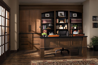 Modelo de despacho tradicional de tamaño medio sin chimenea con paredes beige, suelo de madera oscura, escritorio independiente y suelo marrón