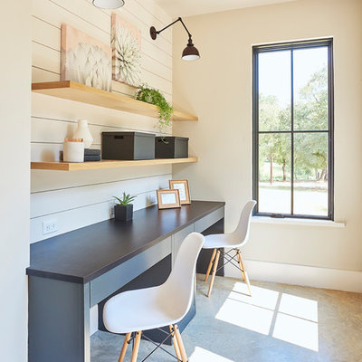 Transitional built-in desk concrete floor and gray floor study room photo in Dallas with white walls