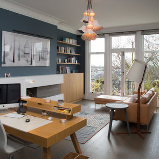 Design ideas for a contemporary home office in London with blue walls, medium hardwood flooring, a standard fireplace, a freestanding desk and brown floors.