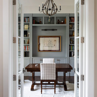 Inspiration för ett mellanstort vintage hemmabibliotek, med beige väggar, mellanmörkt trägolv, ett fristående skrivbord och brunt golv