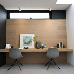 Cette photo montre un bureau tendance avec un mur noir, moquette, un bureau intégré et un sol gris.