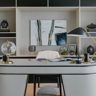 This is an example of a large contemporary home office in London with grey walls, carpet, a freestanding desk and beige floors.