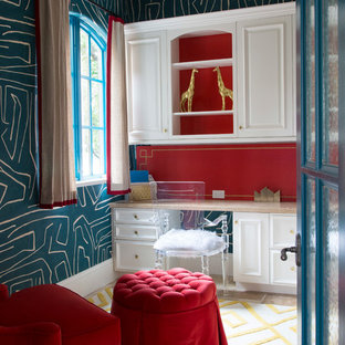 Cette image montre un bureau bohème avec un mur rouge, moquette, un bureau intégré et un sol multicolore.